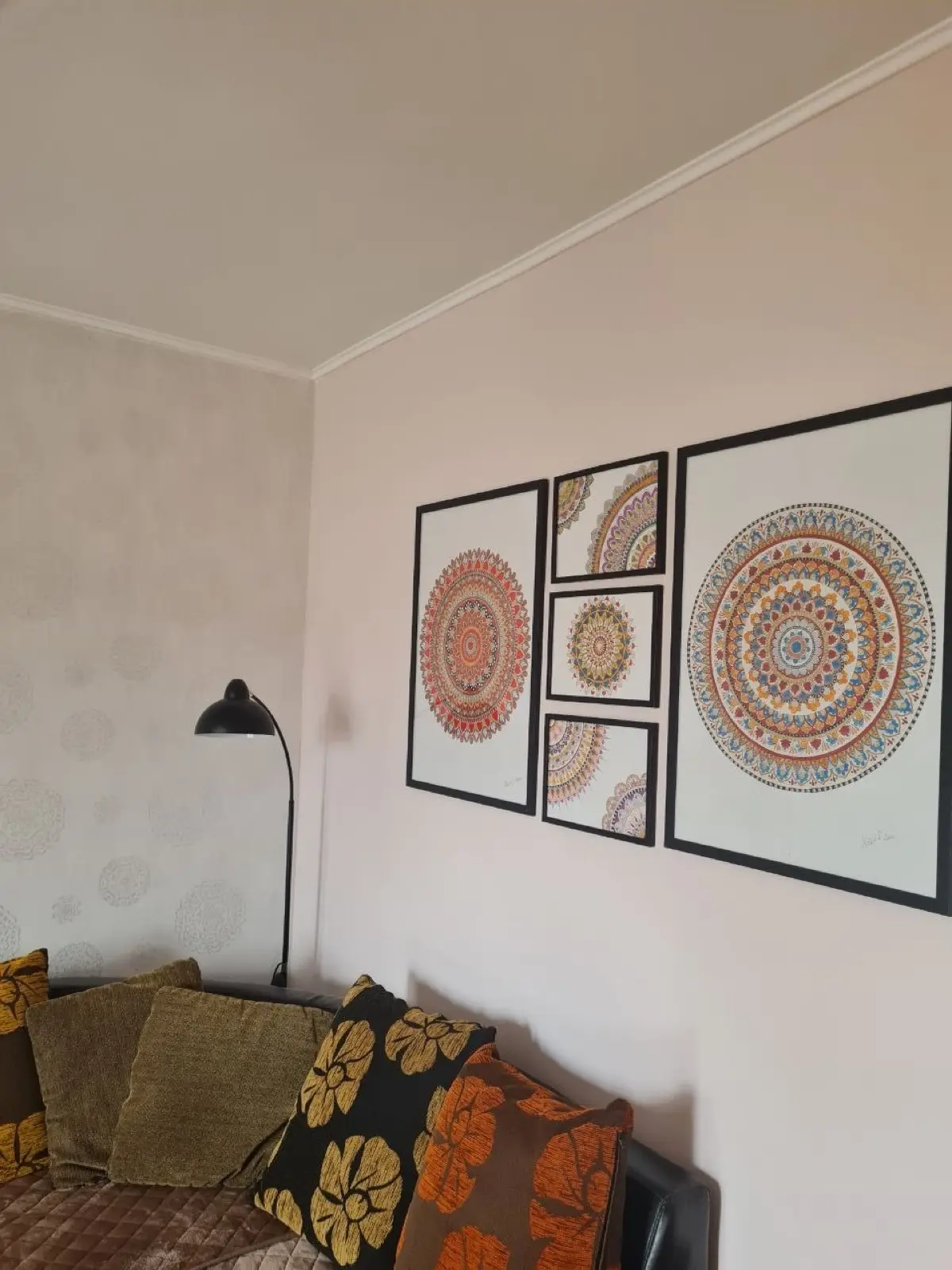 Pet uramljenih mandala postavljenih kao salonski zid iznad sofe u beogradskom dnevnom boravku